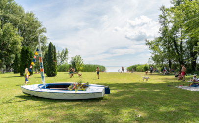 Szép zöld gyep, árnyékot adó fák a strandon